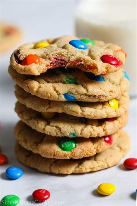 Stack of Chewy M&M cookies with some milk and M&M candies in background ...