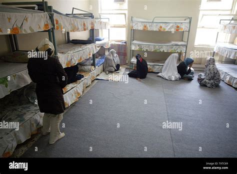 Iranian women prisoners cover their faces as they sit in a room during ...