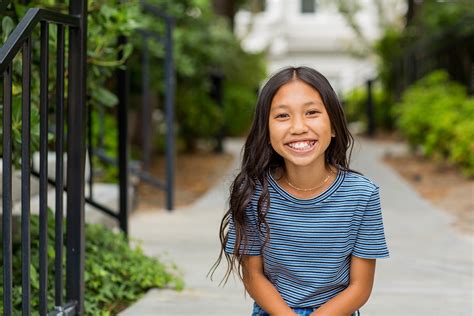 Portrait of a young Asian girl smiling outside. - Lakeland Regional Health