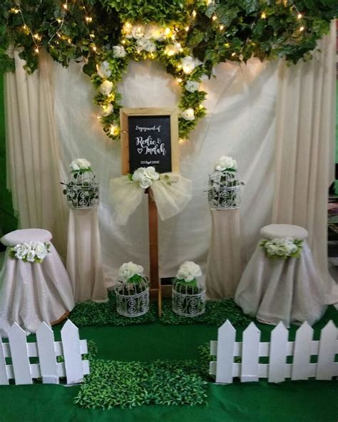 a green and white wedding setup with greenery