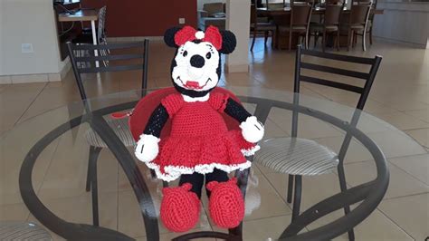 a crocheted mickey mouse doll sitting on top of a glass dining room table