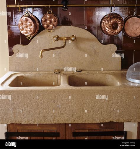 Stone double sink with brass jelly molds Stock Photo - Alamy