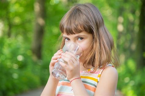 Premium Photo | Little girl drinking water from a glass