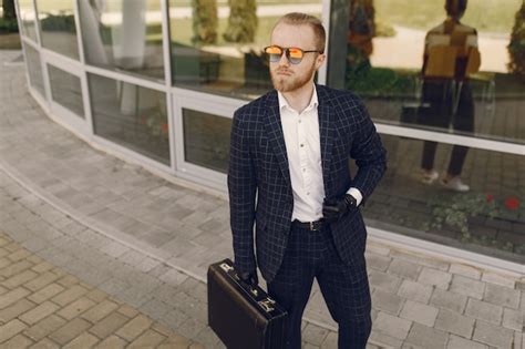 Free Photo | Businessman with suitcase walking in a summer city