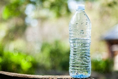 Image of Close up of plastic water bottle outside with green bokeh ...