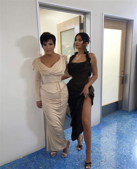 two women in dresses standing next to each other near a mirror and door ...