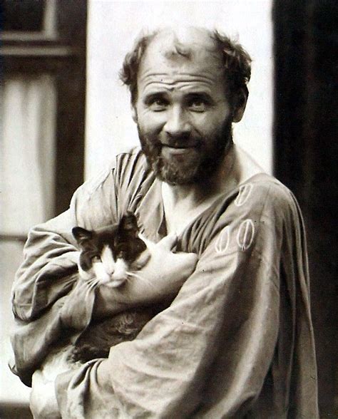 a man holding a cat in his arms and smiling at the camera while wearing a robe