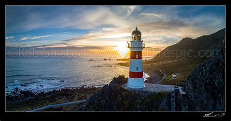 Cape Palliser lighthouse looking out over Palliser Bay at sunset. Aerial panorama, Cape Palliser ...