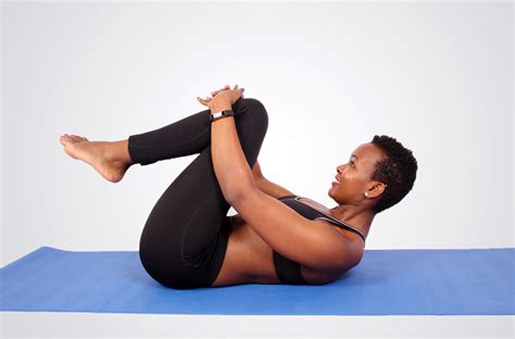 Flexible woman doing yoga stretch at lying on yoga mat
