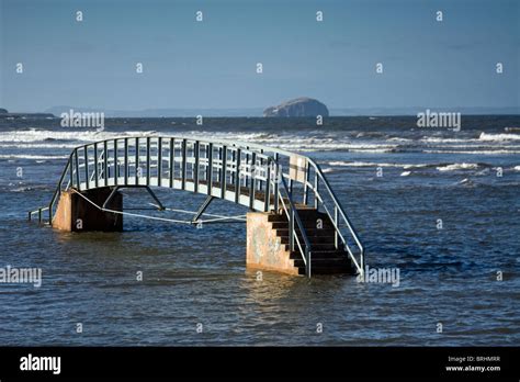 Bridge in sea at Belhaven Beach, Dunbar, Scotland with the Bass Rock in background Stock Photo ...