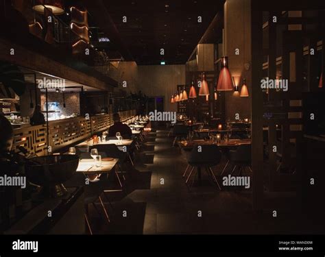 Interior shot of a dark cafe with light brown walls and lights hanging ...