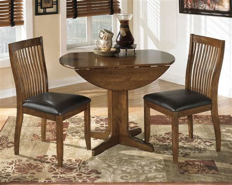 Stuman - Medium Brown - 3 Pc. - Round Drop Leaf Table, 2 Upholstered Side Chairs - EZ Furniture ...