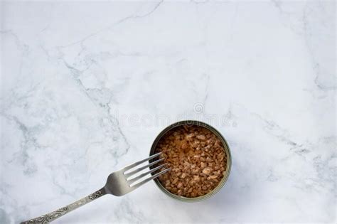 Open Tin Can with Chopped Tuna in Oil on White Marble Kitchen Table ...