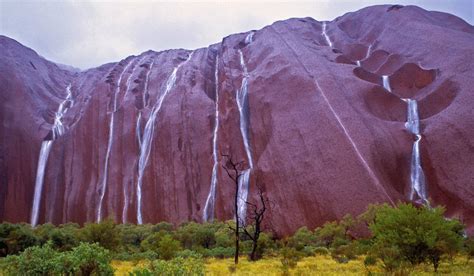 Waterfalls cascade down Uluru's rockface after heavy rainfall Places To Travel, Places To See ...