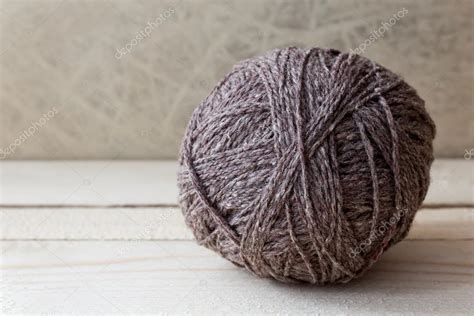 Brown ball of yarn on a wooden table over vintage wallpaper Stock Photo by ©annakukhmar 40788813