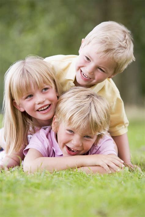 Three Young Children Playing Outdoors Smiling Stock Image - Image of path, pile: 5937009