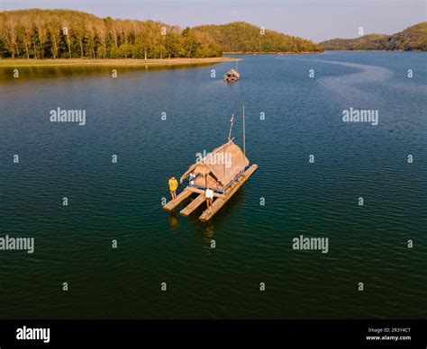 Couple at Huai Krathing lake in North Eastern Thailand Isaan on a bamboo raft at the lake Stock ...