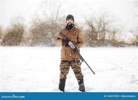 Good Looking Young Man Holding a Rifle and Looking at the Camera Stock ...