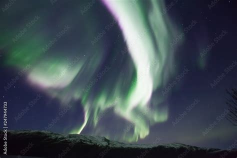 northern lights in Norway in green, blue and violet colours and mountains in the distance Stock ...