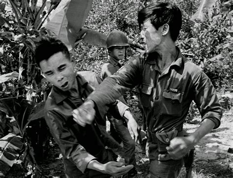 South Vietnamese soldier, punches the face of a suspected Viet Cong guerrilla during an ...