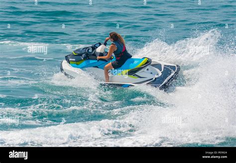 Woman riding a jet ski on the sea in Summer in the UK. Water sports.Jet ...