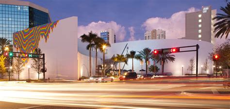 the traffic lights are red and green in front of a large building with palm trees