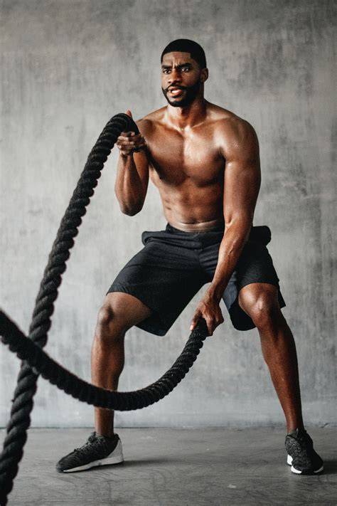 Muscular man working out on the battle ropes in a gym | premium image by rawpixel.com / Teddy ...