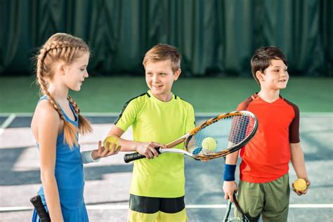 Happy children playing tennis on playground - Australian Fundraising