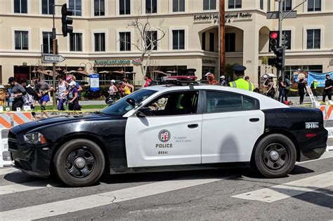 a police car is parked on the side of the road in front of an orange and white barricade