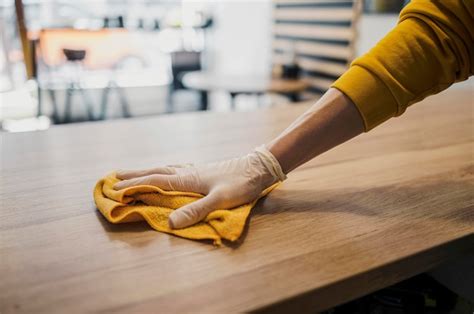 Free Photo | Side view of barista cleaning table while wearing latex glove