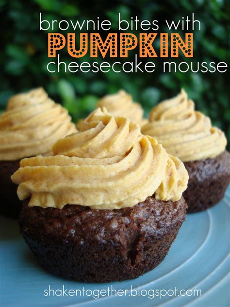 three brownie bites with pumpkin cheesecake mousse on a plate in front of some bushes