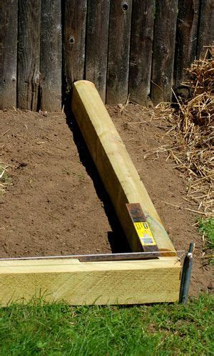 a wooden bench sitting in the middle of a yard next to some dirt and grass