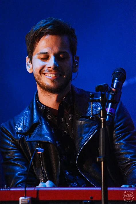 a man in a black leather jacket and headphones smiles at the camera ...