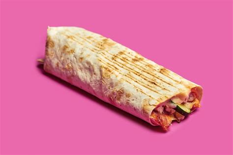 Premium Photo | Large shawarma with chicken, vegetables and sauce on a pink background.
