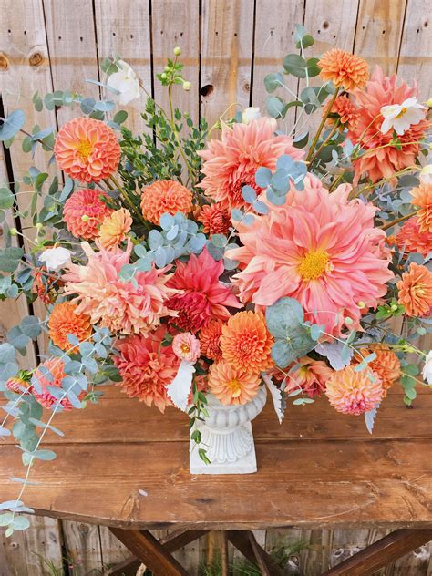 Colorful orange and peach autumn focal arrangement full of dahlias and ...