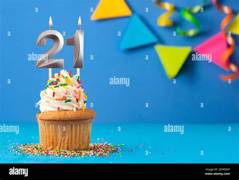 Birthday cake with candle number 21 - Blue background Stock Photo - Alamy