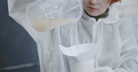 A Woman Transferring Liquid to a Plastic Container · Free Stock Video