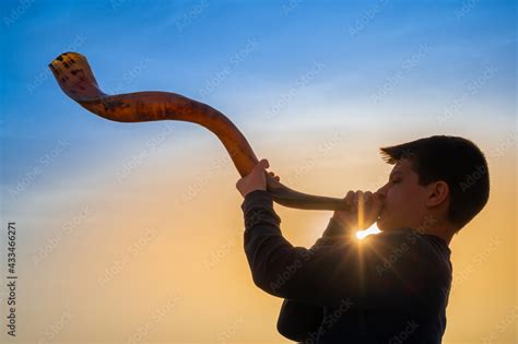 Foto de Teen boy blowing Shofar - ram's horn traditionally used for ...