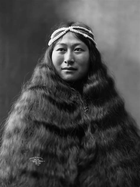 an old black and white photo of a woman with long hair