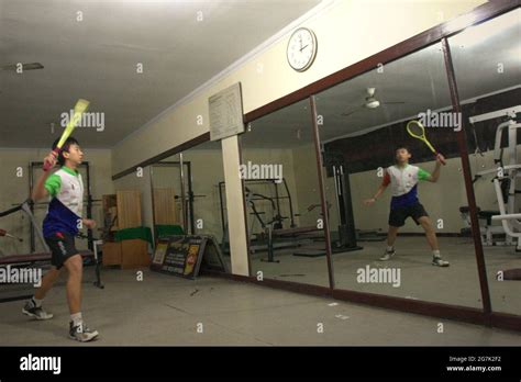 A young badminton athlete is practising various strokes in front of a ...