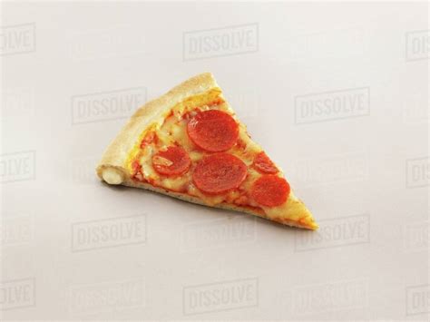 A slice of stuffed crust pizza with pepperoni - Stock Photo - Dissolve