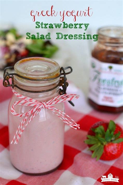 a jar filled with strawberry salad dressing sitting on top of a checkered table cloth