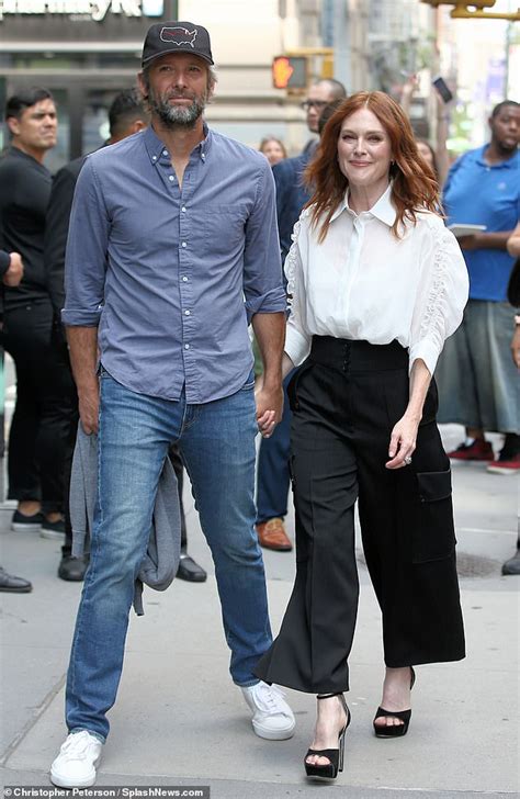 Julianne Moore, 58, smiles as she holds hands with her husband of 23 years Bart Freundlich ...