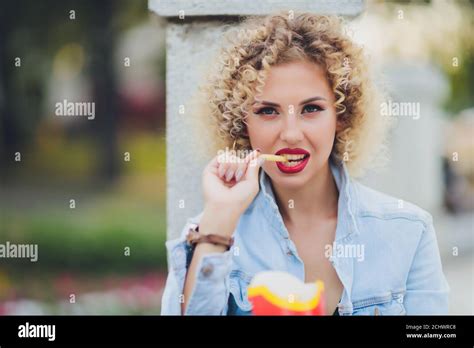 Young Woman Eating A French Fries Street food Stock Photo - Alamy