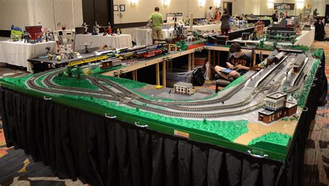 a model train set is on display in a large room with tables and people around it