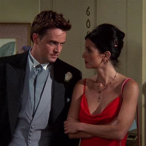 a man in a tuxedo standing next to a woman in a red dress