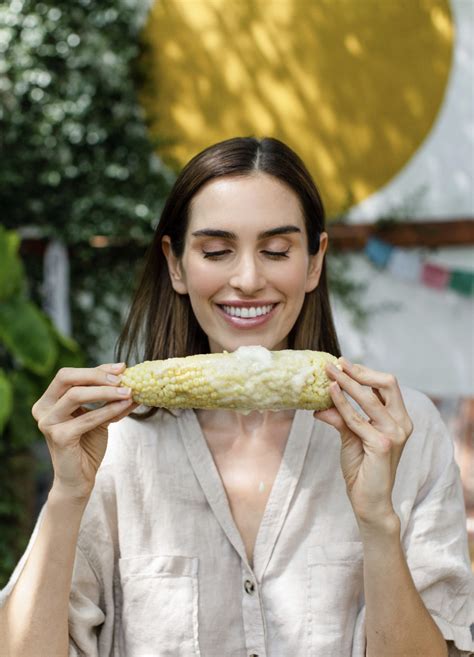 A food photoshoot of a woman holding a corn cob in front of her face by Lauren Montgomery in Los ...