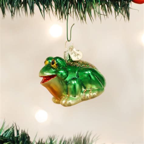 a green frog ornament hanging from a christmas tree