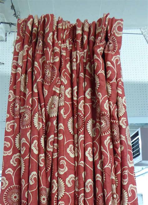 CURTAINS, a pair, red patterned fabric, lined and interlined, each curtain 122cm W gathered by ...