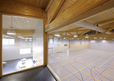 Timber-framed sports hall in the Netherlands with yellow spectator stands by Koppert + Koenis ...